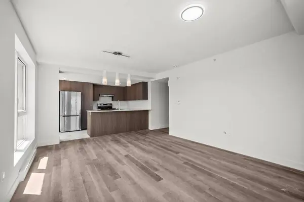 Living room open to the kitchen, with a pendant light, at Tour Laroche, 6311 boul. Gouin Ouest, Montréal