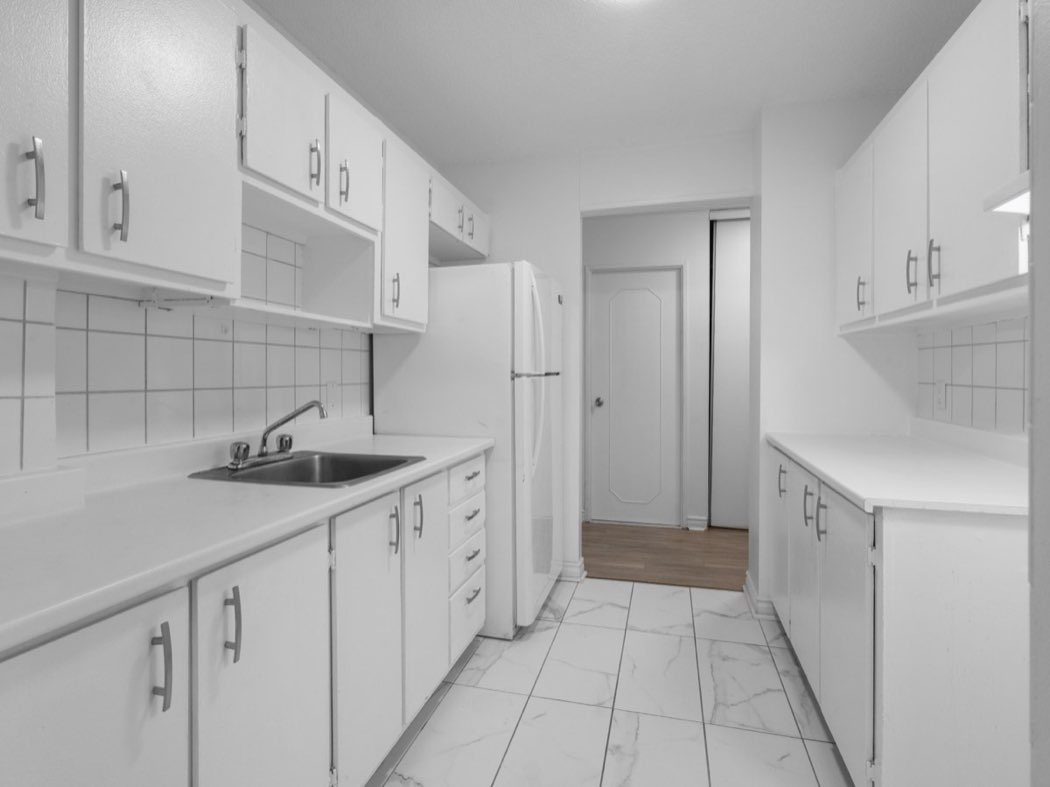 Galley kitchen with white cabinets