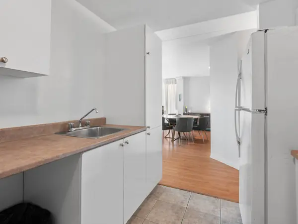 Kitchen counter and refrigerator, the dining area beyond.