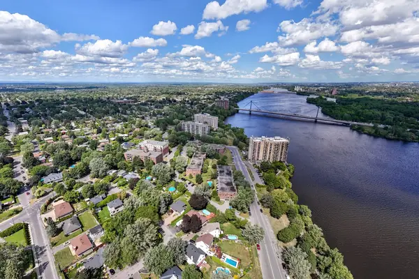 The neighbourhood and the river from the air, with a bridge in the distance.