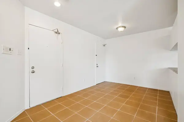 Empty dining area by the entrance door, on a tiled floor
