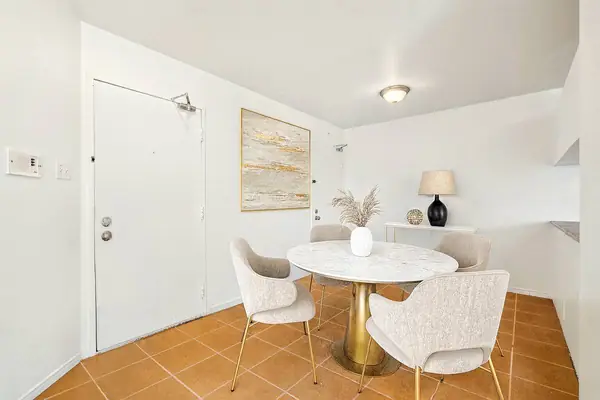 Staged dining area by the entrance door, on a tiled floor