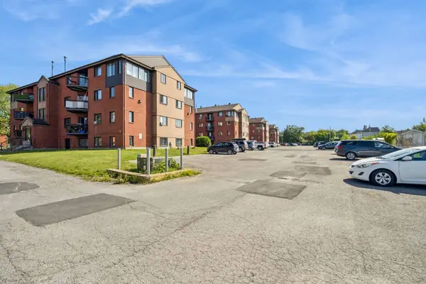 The brick buildings, lawn and outdoor parking of 43-73 Place Mercier