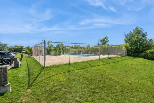 The fenced outdoor pool seen across the lawn
