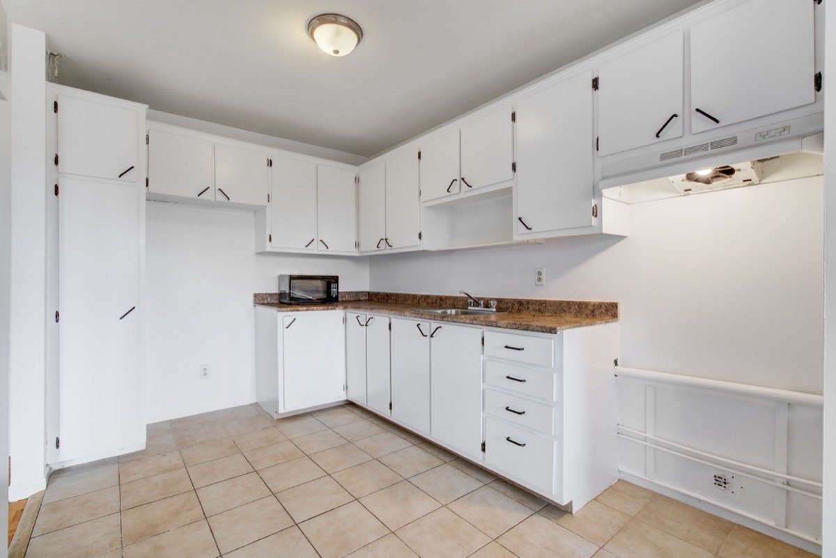 Kitchen with white cabinets and a tiled floor