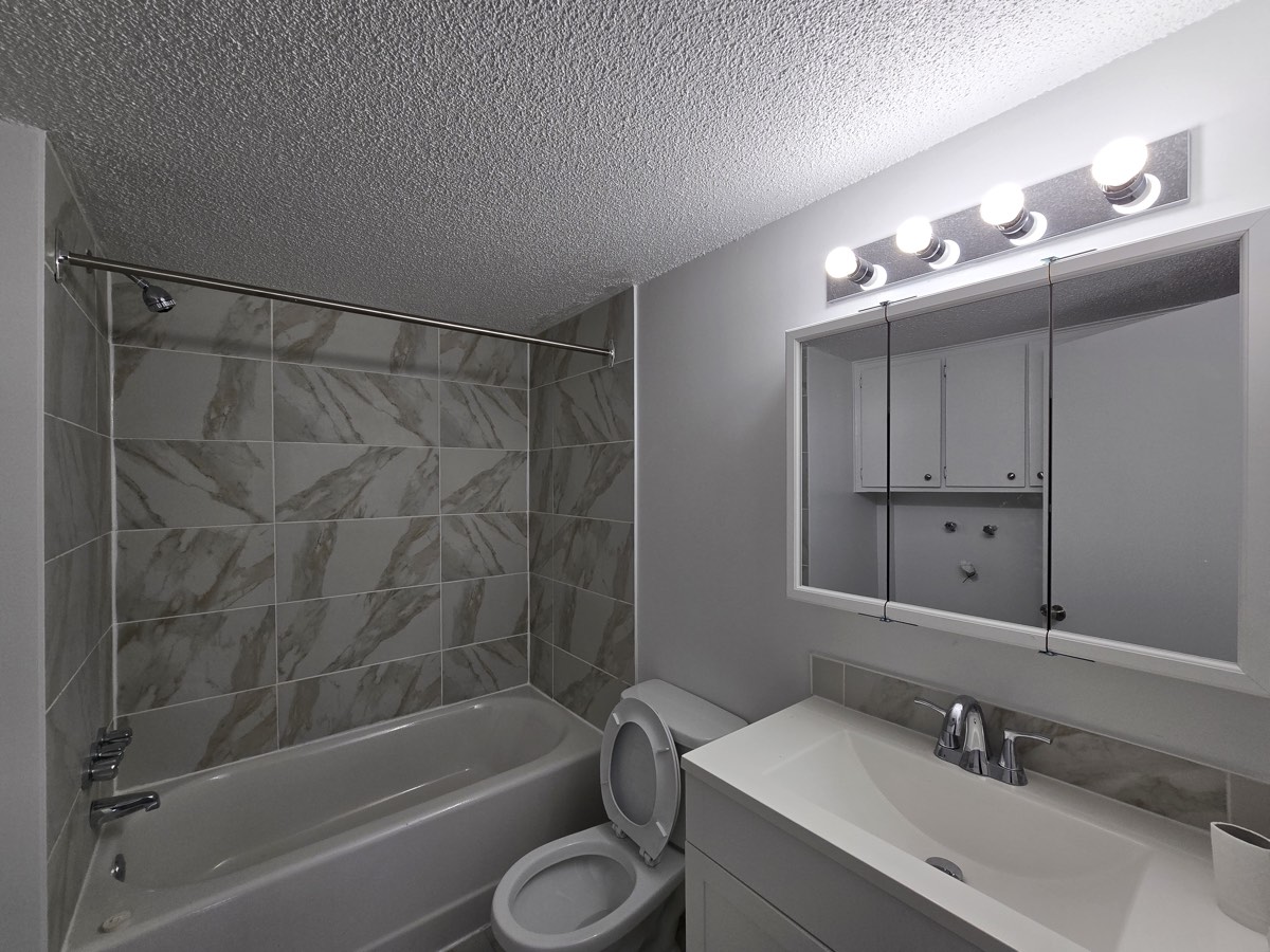 Salle de bain avec céramique à l'aspect marbre et baignoire