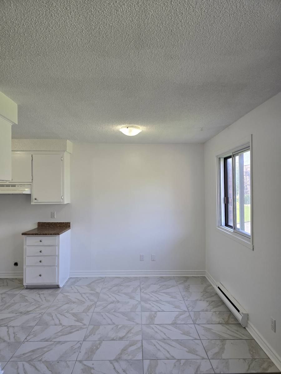 Dining area at the end of the kitchen with a tiled floor and a window in the 5½