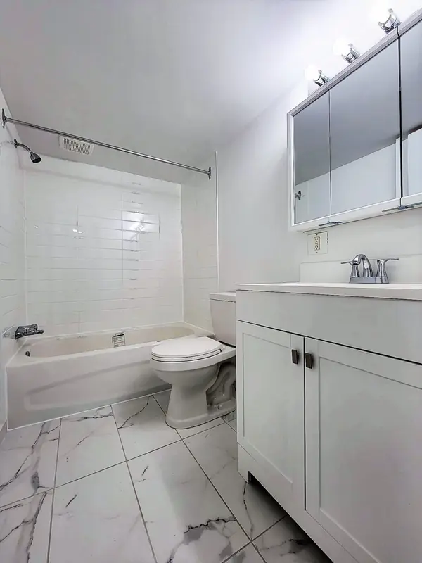 Salle de bain avec baignoire et pharmacie à miroir