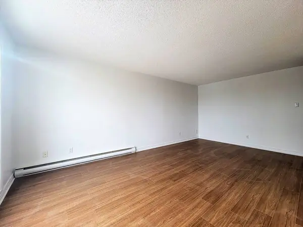 Salon vide avec plancher flottant dans le 4½