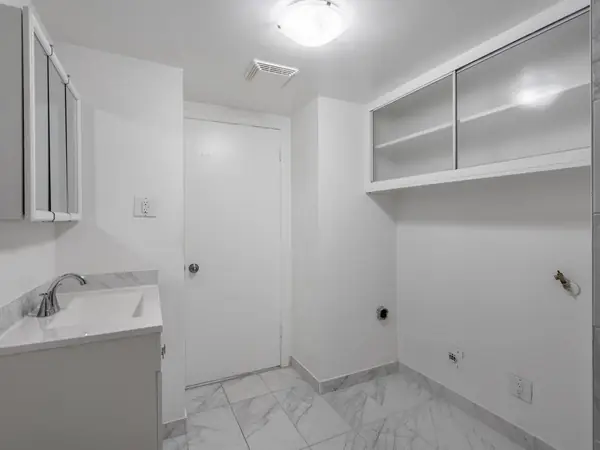 Bathroom vanity with washer and dryer hookups beside it