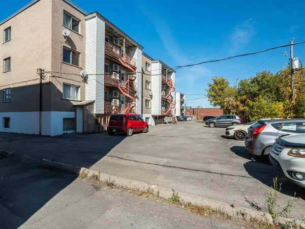 The rear of the buildings with their balconies and the parking lot