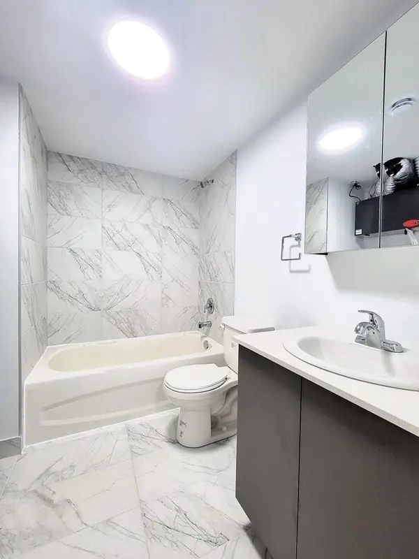 Bathroom with marble-look tiling and a bath