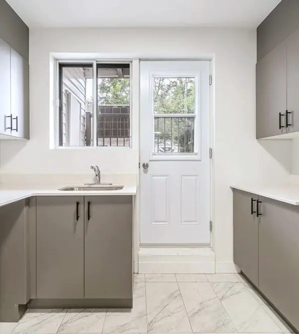 Kitchen with grey cabinets and a back door with a window