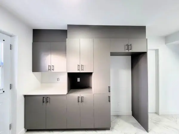 Kitchen wall of grey cabinets with an open shelf