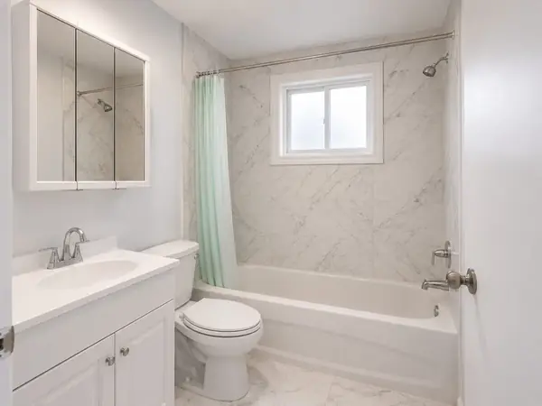 Bathroom with marble-look tiling and a mirrored cabinet in the 4½