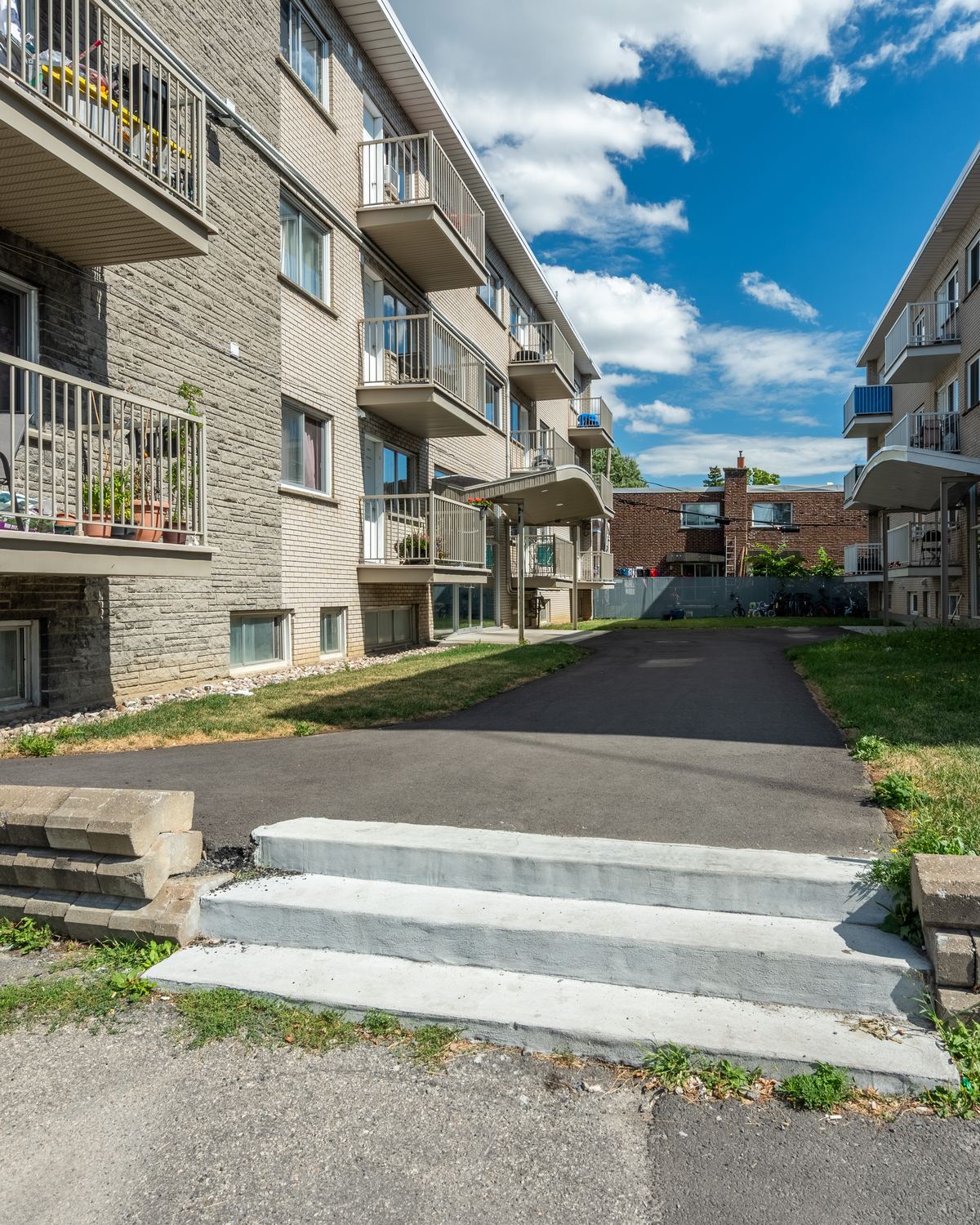 The lane between the brick and stone buildings at 1020 rue de Salaberry, under a blue sky